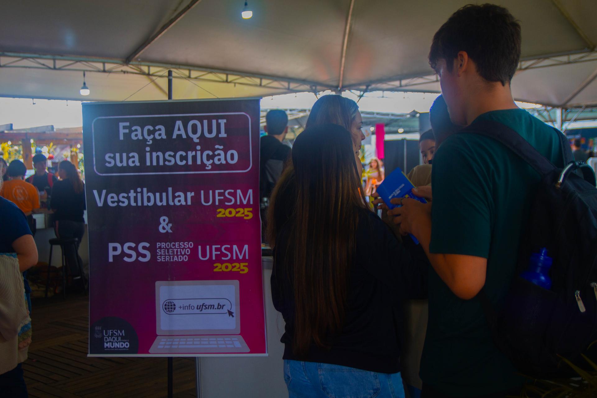 Foto colorida horizontal de estudantes no Descubra. Os estudantes estão de costas do lado direito. Um banner na cor rosa traz o texto "Faça a sua inscrição aqui"