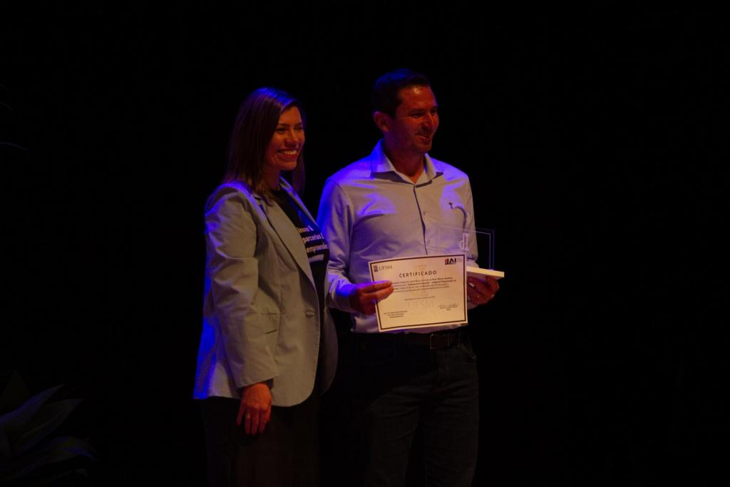 Foto colorida horizontal do professor Marcio Mazutti recebendo prêmio