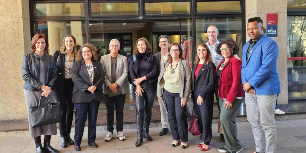 Foto colorida com grupo de pessoas em frente ao Salão de Atos da UFRGS
