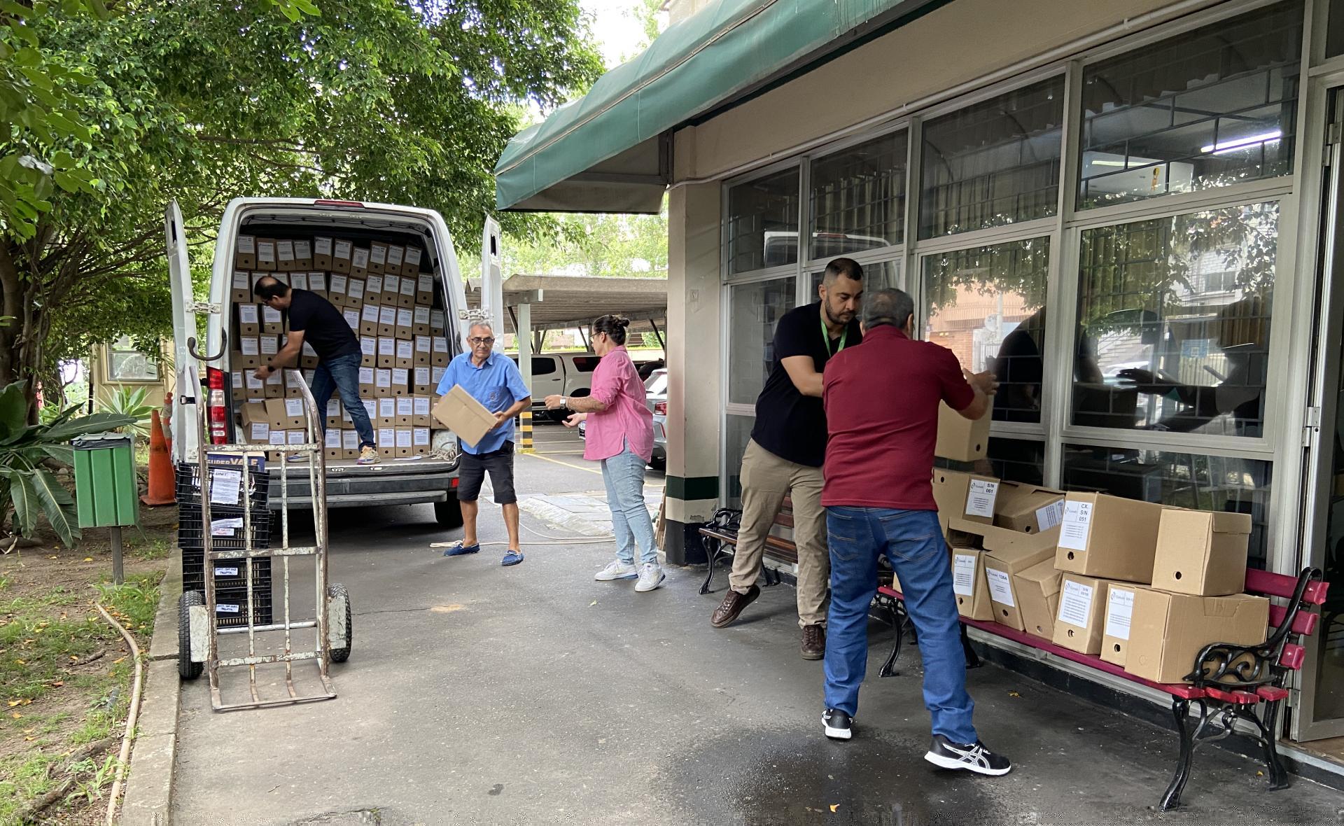 Carro e servidores do Hub.Doc entregando caixas de documentos nas instituições parceiras em Porto Alegre