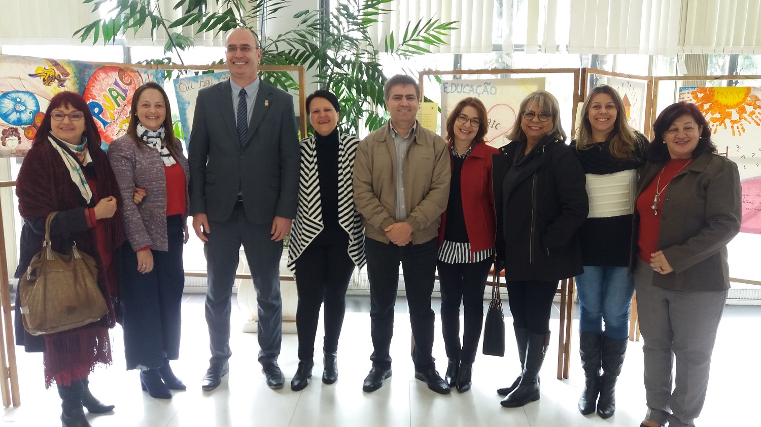 Dez pessoas sorrindo alinhadas umas às outras