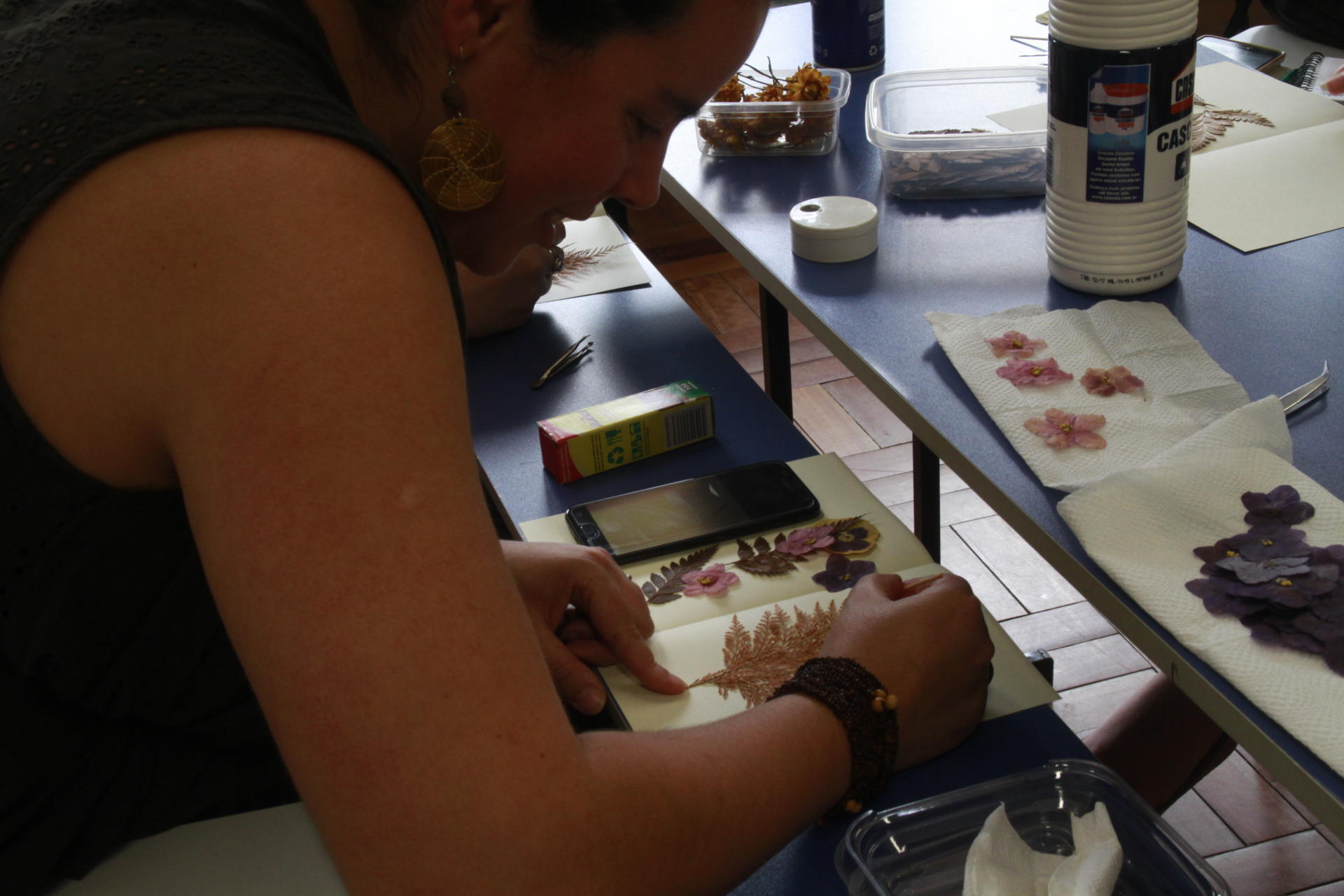 Mulher fazendo trabalho manual com folha seca