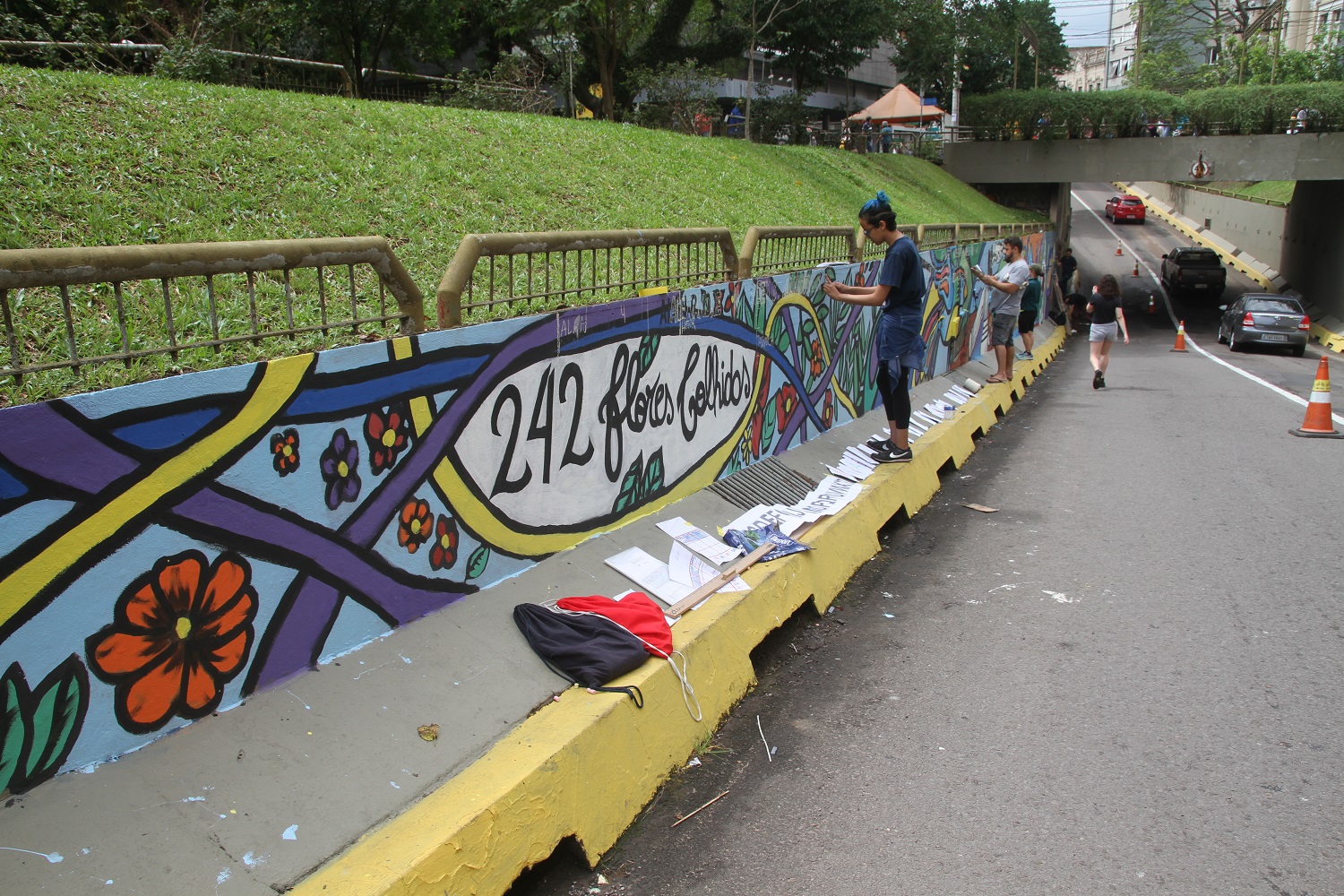 Painel colorido, no viaduto Evandro Behr, com várias pessoas pintando