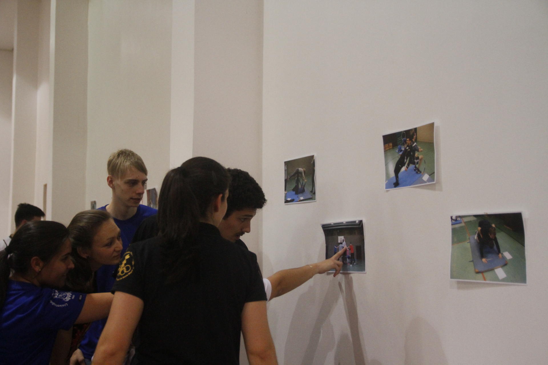 Seminário Internacional de Educação Física Estudantes avaliam fotos fixadas na parede, que representam diferentes movimentos