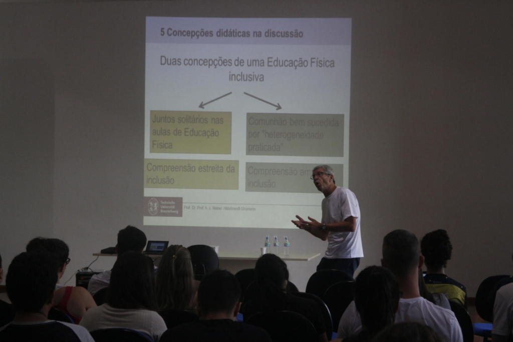 Seminário Internacional de Educação Física À frente professor apresenta palestra enquanto público observa